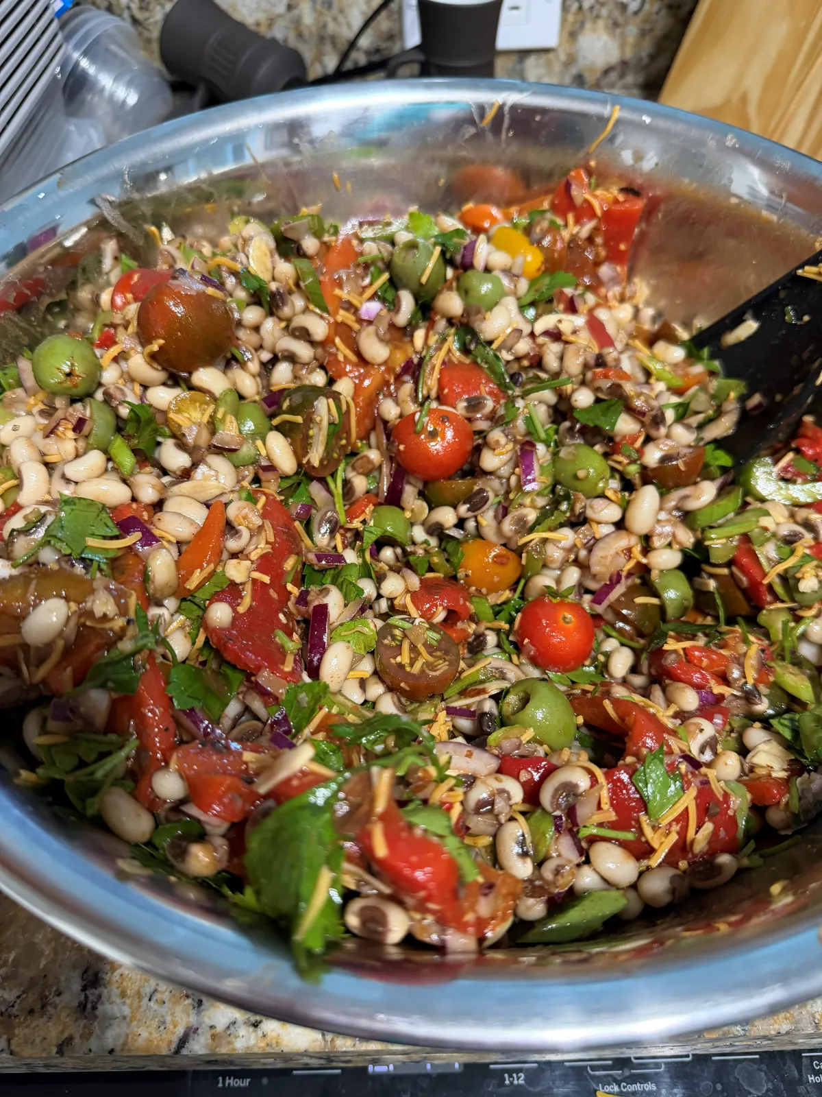 The same salad tossed together, with the dressing coating the peas, tomatoes and roasted red peppers