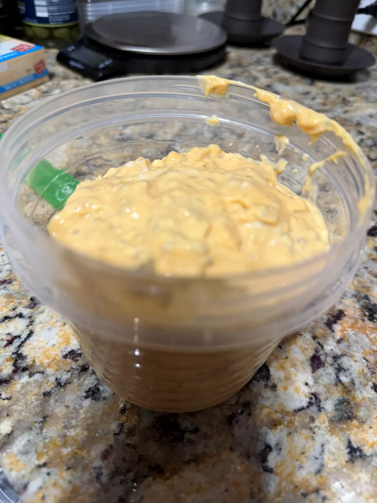 A single serving of the mixed pumpkin gloop in a plastic tub: smooth, dense and orange from top to bottom